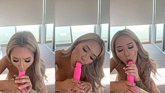 sucking the tip of a pink rubber dildo